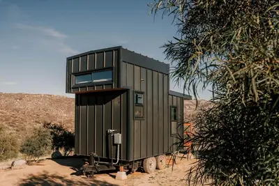 a green tiny house on a trailer in the desert at Unplug in a Rustic-Chic Tiny Home: Stargazing Patio, Cookout Space & Nature Views in Aguanga, California in Aguanga