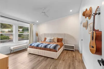 a bedroom with a bed and a guitar on the wall at Avocado Akres Awaits Near Monserate Winery in Fallbrook