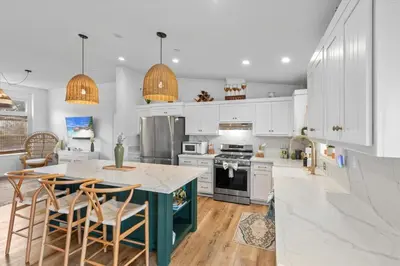 a kitchen with white cabinets and a blue island with chairs at Avocado Akres Awaits Near Monserate Winery in Fallbrook