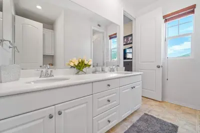 a white bathroom with two sinks and a large mirror at 430 Large home sleeps 10 in Fallbrook