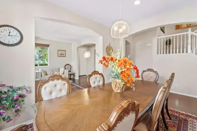 a dining room with a table and chairs and a clock at 430 Large home sleeps 10 in Fallbrook