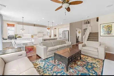a living room with white furniture and a kitchen at 430 Large home sleeps 10 in Fallbrook