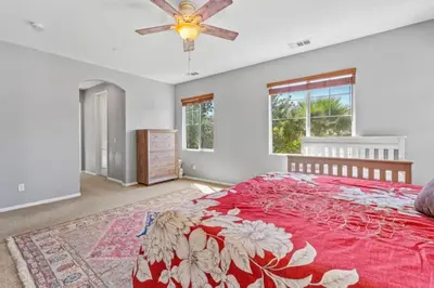 a bedroom with a red bed and a ceiling fan at 430 Large home sleeps 10 in Fallbrook