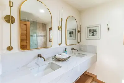 a bathroom with two sinks and two mirrors at 450A Ocean View beach house in Dana Point
