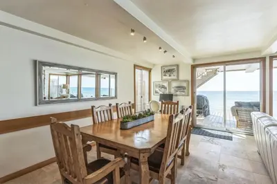a dining room with a table and chairs and the ocean at 450A Ocean View beach house in Dana Point
