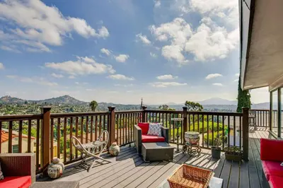 a deck with a couch and chairs on a balcony at 474 Oasis w Amazing Views Huge Pool in La Mesa