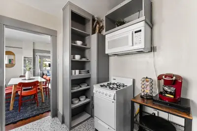 a kitchen with a white stove top oven next to a table at The Treehouse by Coastline Vacation Rentals in San Diego