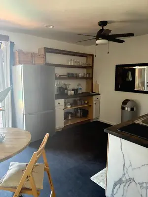 a kitchen with a stainless steel refrigerator and a table at Painted sky casita in San Diego