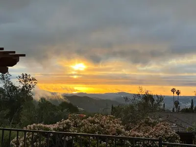 a sunset with the sun setting over the mountains at Painted sky casita in San Diego