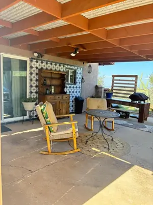 a patio with a table and chairs under a roof at Painted sky casita in San Diego