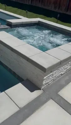 a swimming pool with a stone wall around it at Modern Family Oasis in San Jacinto