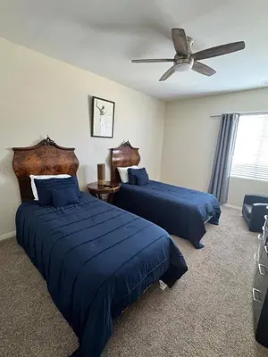 a bedroom with two beds and a ceiling fan at Modern Family Oasis in San Jacinto