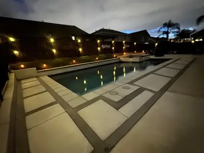 a swimming pool at night with lights at Modern Family Oasis in San Jacinto
