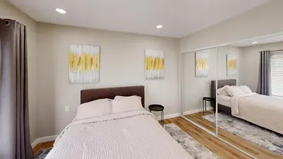 a bedroom with two beds and a mirror at Spacious 4BR Loft - Outdoor Movie Theater in El Cajon