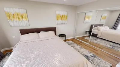 a bedroom with two beds and a mirror at Spacious 4BR Loft - Outdoor Movie Theater in El Cajon