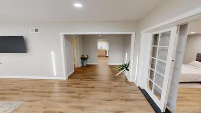 a living room with a bed and a wooden floor at Spacious 4BR Loft - Outdoor Movie Theater in El Cajon