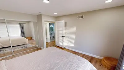 a bedroom with a white bed and a window at Spacious 4BR Loft - Outdoor Movie Theater in El Cajon