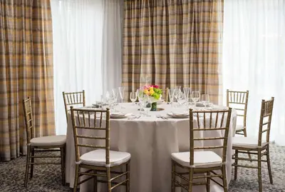 a table with wine glasses and flowers on it at Homewood Suites by Hilton Aliso Viejo Laguna Beach in Aliso Viejo