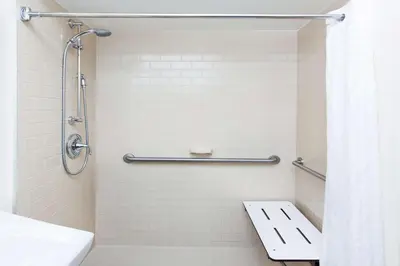 a bathroom with a shower with a toilet and a sink at Sonesta Simply Suites Irvine Spectrum in Irvine