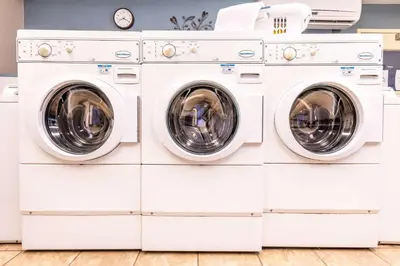 three washing machines stacked up in a laundry room at Sonesta Simply Suites Irvine Spectrum in Irvine
