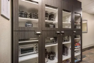 a kitchen cabinet with glass doors and a microwave at Sonesta Simply Suites Irvine Spectrum in Irvine