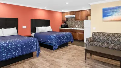 a hotel room with two beds and a couch at Scandia Motel in Carlsbad