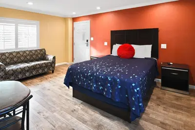 a hotel room with a bed and a couch at Scandia Motel in Carlsbad