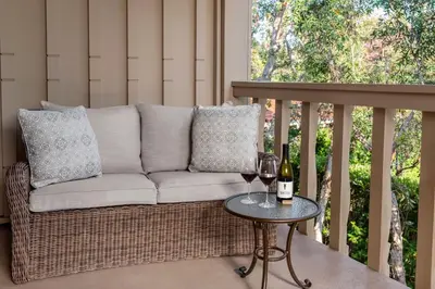 a couch on a porch with a table with wine glasses at Rancho Bernardo Inn in Rancho Bernardo