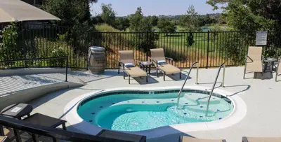 a hot tub in a patio with chairs and a table at Temecula Creek Inn in Temecula
