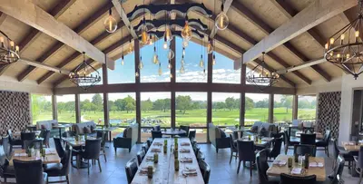 a dining room with tables and chairs and a large window at Temecula Creek Inn in Temecula