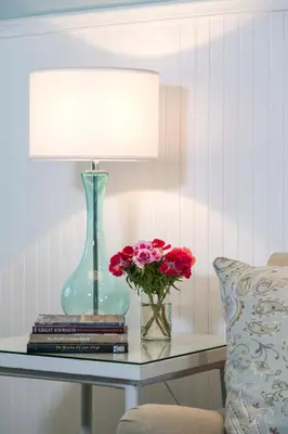 a table with a lamp and a vase with flowers on it at Scripps Inn in San Diego