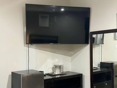 a large flat screen tv hanging on a wall at Rodeway Inn El Cajon - San Diego East in El Cajon