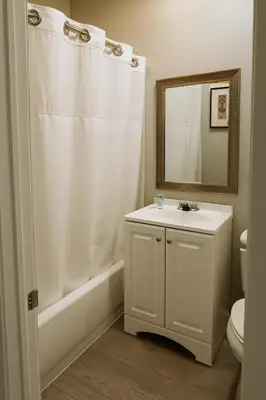 a white bathroom with a sink and a mirror at Rodeway Inn El Cajon - San Diego East in El Cajon