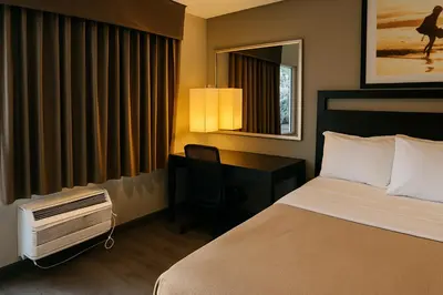 a hotel room with a bed and a desk with a computer at Rodeway Inn El Cajon - San Diego East in El Cajon