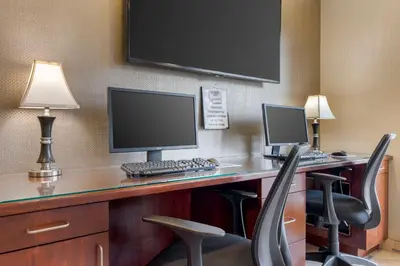 a desk with a computer and two monitors on it at Best Western Plus Marina Shores Hotel in Dana Point