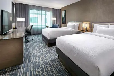 a hotel room with two beds and a flat screen tv at Hilton Garden Inn San Diego Downtown/Bayside, CA in San Diego