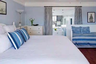 a bedroom with a large white bed with blue pillows at Newport Beach Hotel in Newport Beach