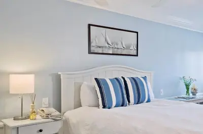 a bedroom with a white bed with blue pillows at Newport Beach Hotel in Newport Beach