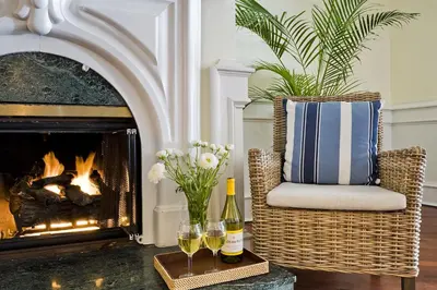 a living room with a fireplace and a chair with wine glasses at Newport Beach Hotel in Newport Beach