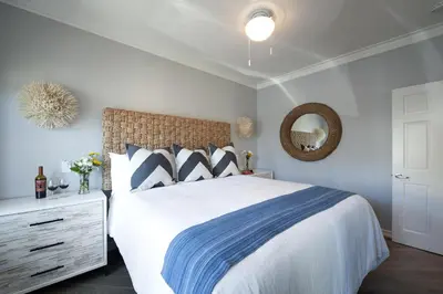 a bedroom with a bed with a blue and white comforter at Newport Beach Hotel in Newport Beach