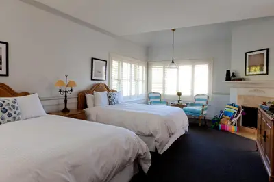 a bedroom with two beds and a fireplace at Blue Lantern Inn, A Four Sisters Inn in Dana Point