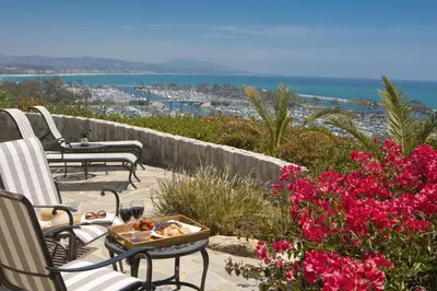 a patio with chairs and a tray of food and flowers at Blue Lantern Inn, A Four Sisters Inn in Dana Point