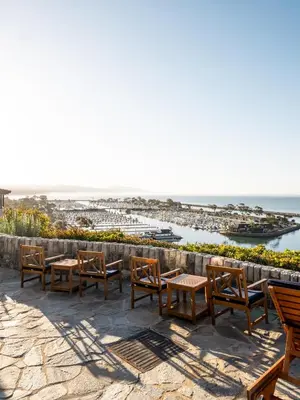 a group of tables and chairs on a patio overlooking the ocean at Blue Lantern Inn, A Four Sisters Inn in Dana Point