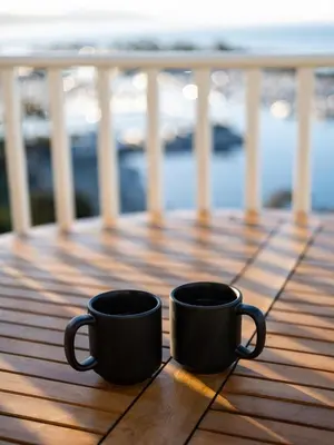 two black coffee cups sitting on a wooden deck at Blue Lantern Inn, A Four Sisters Inn in Dana Point