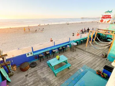 an overhead view of a beach with a blue table and benches at ITH San Diego Beach Bungalow Surf Hostel in San Diego
