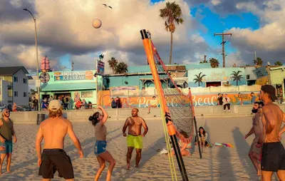 a group of people playing volley ball on the beach at ITH San Diego Beach Bungalow Surf Hostel in San Diego