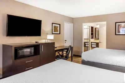 a hotel room with a bed and a desk with a television at Best Western Country Inn Temecula in Temecula