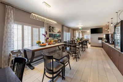 a dining room with tables and chairs and a kitchen at Best Western Country Inn Temecula in Temecula