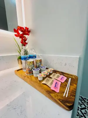 a tray with treats and a vase with red flowers at Villa Serena in El Cajon