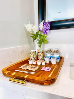 a wooden tray with a vase of flowers on a counter at Villa Serena in El Cajon